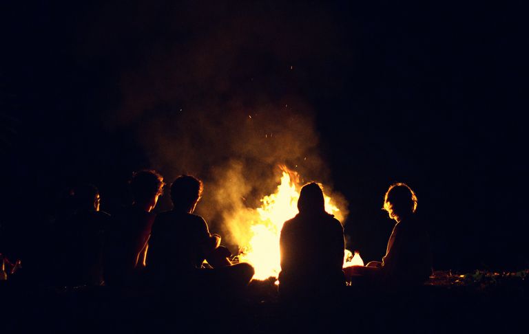 Modern humans continue the ancient tradition of gathering around a campfire.